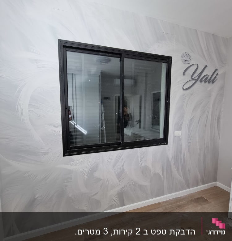 קיר עם טפט נוצות לבנות וחלון שחור